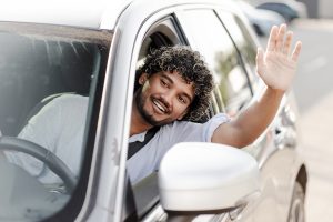 young man waving from car window while driving 2025 02 20 10 21 17 utc Steffy Driver